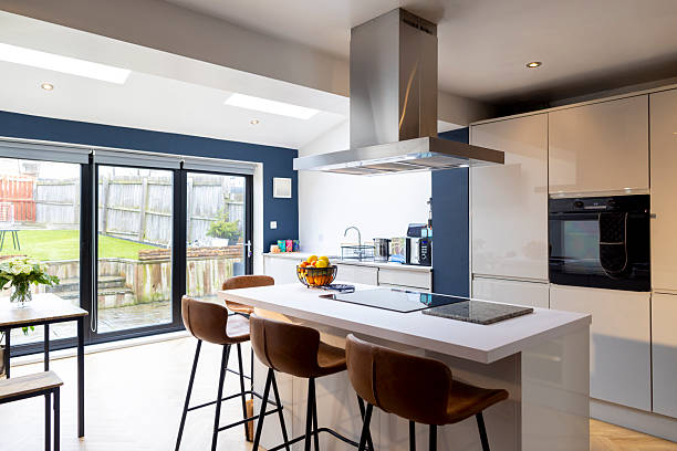 View of a modern kitchen featuring an island with leather bar stools